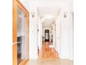 Inviting hallway with gleaming hardwood floors, neutral walls, and decorative lighting at 4014 Ivy Trace Ln, Ellenwood, GA 30294