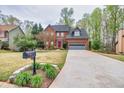 Attractive brick home with a lush green lawn and a long driveway leading to an attached garage at 2739 Springfount Trl, Lawrenceville, GA 30043