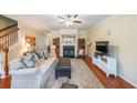 Bright living room with a cozy fireplace, wood floors, and a staircase to upper level at 3729 Town Square Nw Cir # 6, Kennesaw, GA 30144