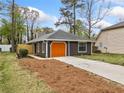Cozy home showcasing an orange garage door, dark siding, and newly landscaped garden bed at 4540 Bryant Rd, Buford, GA 30518