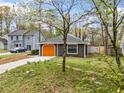 View of the house displaying an orange garage door, complementing the exterior, and landscaping at 4540 Bryant Rd, Buford, GA 30518