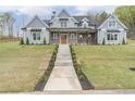 Beautifully landscaped front yard leading up to a covered front porch and inviting two-story home at 3068 Turning Creek Trail, Dacula, GA 30019