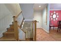 View of the staircase with wood steps, white banisters, and artwork along the wall at 80 La Rue Nw Pl, Atlanta, GA 30327
