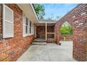 Side view of the red brick courtyard with an arched entryway and spacious concrete patio at 1150 Tinsley Nw Dr, Conyers, GA 30012