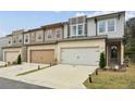 Attractive townhome with light brick, neutral siding, and a two-car garage on a manicured lawn at 2310 Portrush Se Way, Atlanta, GA 30339