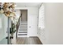 Bright foyer featuring hardwood floors, staircase, white door, and tasteful decor at 2310 Portrush Se Way, Atlanta, GA 30339