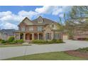 Stately two-story brick home with a covered porch, attached garage, and well-maintained front lawn at 5224 Brendlynn Dr, Suwanee, GA 30024