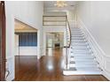 Bright, open foyer features soaring ceilings and a grand staircase with elegant wood trim at 700 Henley Fields Cir, Johns Creek, GA 30097