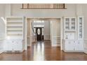 Spacious living room with hardwood floors, built-in bookshelves, and a view of the front entrance at 700 Henley Fields Cir, Johns Creek, GA 30097
