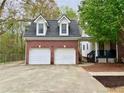 Two-car garage with white doors and a brick facade, offering ample parking at 2210 Holly Springs Rd, Rockmart, GA 30153
