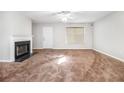Spacious living room features plush carpeting, a ceiling fan, and a cozy fireplace at 3651 Sapphire Ct, Decatur, GA 30034