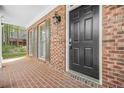 Close-up of brick front porch with classic black front door and decorative shuttered windows at 4522 Willow Oak Trl, Powder Springs, GA 30127