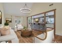 Bright living room with hardwood floors, white sofas, and an open layout to the kitchen at 475 Brown Thrasher Ct, Alpharetta, GA 30009