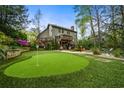 Expansive backyard with putting green, tiered landscaping, and an inviting pool area for outdoor enjoyment at 4688 Oakleigh Manor Dr, Powder Springs, GA 30127