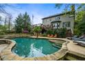 Beautiful backyard featuring a large pool with stone surround, ample seating, and lush landscaping at 4688 Oakleigh Manor Dr, Powder Springs, GA 30127