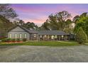 Inviting single-story home featuring a cozy front porch, well-maintained lawn, and mature landscaping at 6585 Queen Mill Se Rd, Mableton, GA 30126