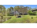 Charming home featuring a well-manicured lawn, mature trees, and a serene pond, perfect for outdoor enjoyment at 6585 Queen Mill Se Rd, Mableton, GA 30126