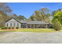 Inviting single-story home featuring a cozy front porch, well-maintained lawn, and mature landscaping at 6585 Queen Mill Se Rd, Mableton, GA 30126