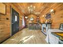 Charming room featuring wood paneling, a stone fireplace, a cozy bar area, and elegant lighting at 6585 Queen Mill Se Rd, Mableton, GA 30126