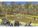 Picturesque pond view with fountain, string lights, and outdoor seating area creating a serene retreat at 6585 Queen Mill Se Rd, Mableton, GA 30126