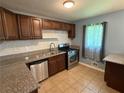 Updated kitchen with stainless steel appliances, granite countertops, double sink, and tile floors at 1464 Colony East Cir, Stone Mountain, GA 30083