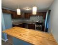 Beautiful kitchen with updated countertops, tiled backsplash, stainless steel appliances, and a butcher block breakfast bar at 1464 Colony East Cir, Stone Mountain, GA 30083