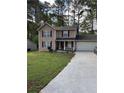 Charming two-story home with a well-manicured lawn and long concrete driveway at 230 Blue Heron Dr, Jonesboro, GA 30238