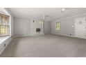 Spacious living room is equipped with a cozy white brick fireplace and neutral carpet at 4606 Greensprings Rd, College Park, GA 30337