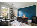A dedicated home office space with large windows, a comfortable chair, and a stylish modern desk at 5296 Camden Lake Nw Pkwy, Acworth, GA 30101