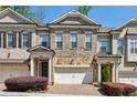 Charming brick townhouse with stone accents, covered porch, and attached two-car garage at 828 Canterbury Overlook Ne, Atlanta, GA 30324