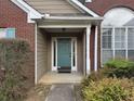 Close-up of the home's front porch featuring a teal front door, brick accents, and manicured landscaping at 140 Grayview Ct, Grayson, GA 30017