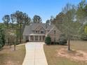 Beautifully designed brick and stone home with a long driveway and lush trees surrounding the property at 7497 Treehouse Ct, Douglasville, GA 30135