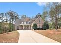 Charming home featuring a blend of brick and stone, manicured landscaping, and a spacious driveway at 7497 Treehouse Ct, Douglasville, GA 30135