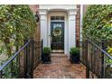 Charming brick entryway leads to a black front door with decorative wreath and manicured landscaping at 2630 Milford Ln, Alpharetta, GA 30009