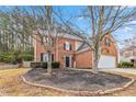 Traditional brick home with a well-kept lawn and mature trees in a desirable neighborhood at 5775 Stephens Mill Dr, Sugar Hill, GA 30518