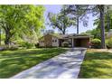 Lovely single-story home featuring a well-manicured lawn, blooming shrubs, and convenient carport at 1629 Anita Ne Pl, Atlanta, GA 30306