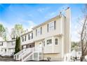 A two-story townhouse with light vinyl siding, black shutters, and a welcoming front porch at 6331 Wedgeview Dr, Tucker, GA 30084