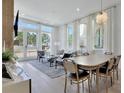 Inviting living area with hardwood flooring, large windows dressed with white curtains and a patio door for seamless indoor-outdoor living at 190 Rolison Way, Fayetteville, GA 30214