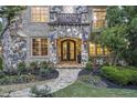 Beautiful stone entryway with custom iron doors and manicured landscaping at 854 Club Moss Ct, Marietta, GA 30068
