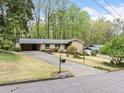 Inviting one-story home with long driveway, carport, beautiful landscaping, and a mix of mature trees at 1478 Biltmore Ne Dr, Atlanta, GA 30329