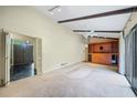 Bright living room featuring high ceilings, wood beams, a fan, built-in storage, and sliding glass door at 1478 Biltmore Ne Dr, Atlanta, GA 30329