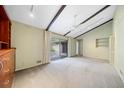 Spacious living room featuring carpet, built-in storage, sliding glass doors, and accent ceiling beams at 1478 Biltmore Ne Dr, Atlanta, GA 30329