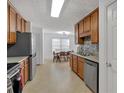 Galley kitchen features wood cabinets, stainless appliances, tiled backsplash, and eat-in dining area at 2793 Saddle Horn, Snellville, GA 30039
