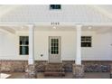 Inviting front porch showcasing brick accents, white pillars, and a stylish front door with glass panes at 3143 Lee Cir, Buford, GA 30518