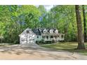 Beautiful home exterior with a driveway, a big front lawn, mature trees, and a front porch at 2100 Kings Valley Dr, Lawrenceville, GA 30043