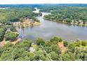 Lakefront property highlighting the lake, with a home nestled in mature trees in a serene setting at 590 Yancey Cir, Covington, GA 30014