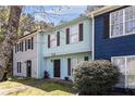 Attractive townhome with a light blue facade, complemented by lush greenery and a well-manicured lawn at 732 Jamestown Xing, Jonesboro, GA 30238