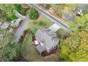 An aerial view of a gray roofed home with a deck and umbrella surrounded by lush greenery at 2811 Shady Valley Ne Dr, Brookhaven, GA 30324