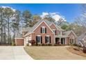 Beautiful brick home with an attached two-car garage, lovely landscaping, and a welcoming front entrance at 214 Cedar Woods Way, Canton, GA 30114