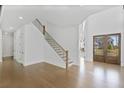Bright, open foyer boasts hardwood floors, a striking staircase, and elegant double doors leading outside at 7043 Foundry Dr, Woodstock, GA 30188